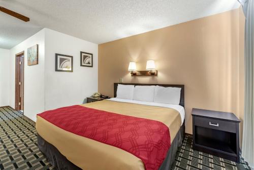 a hotel room with a large bed with a red blanket at Econo Lodge La Junta in La Junta