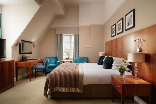 a hotel room with a bed and a desk and chairs at The Grand, York in York