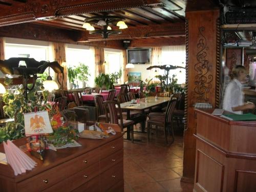 a woman standing in a restaurant with tables and chairs at Gasthof und Pension Haunschmid in Rechberg