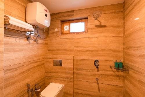 a bathroom with a toilet and a shower at Zen Manali by Keekoo Stays in Manāli