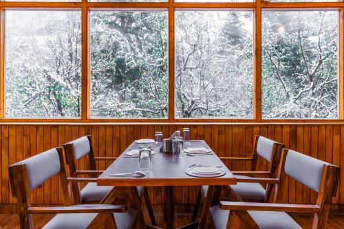 a dining room with a table and four chairs at Zen Manali by Keekoo Stays in Manāli