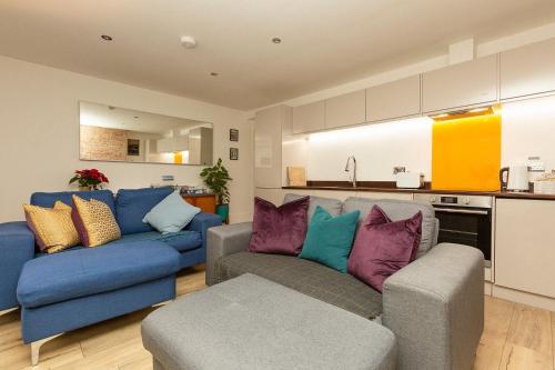 a living room with two couches and a kitchen at Stylish Coastal Retreat with Hot Tub & Log Burner in Margate in Margate
