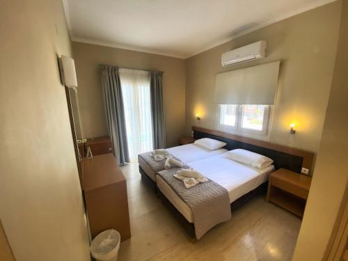 a bedroom with a bed and a large mirror at Cosmos Hotel in Vasiliki