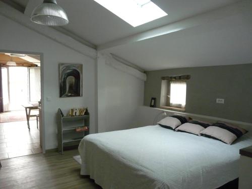 a bedroom with a white bed and a table at gites Les Lebes - Grange loft in Sempesserre