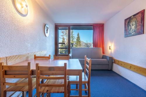 Un comedor con una mesa y sillas y un sofá. en LES ARCS 1800 Village du Charvet, en Bourg-Saint-Maurice