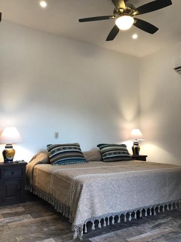 a bedroom with a bed with a ceiling fan at Aventura Pacifico Boutique Suites & Villas in Bucerías