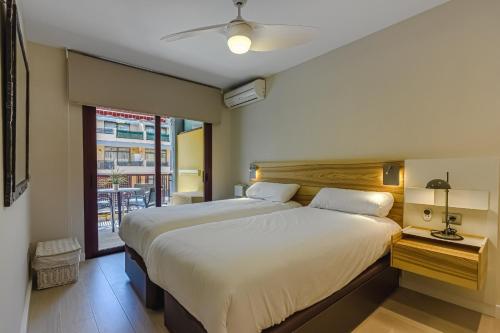 um quarto com 2 camas e uma janela em Olivia FREE WIFI em Puerto de Santiago