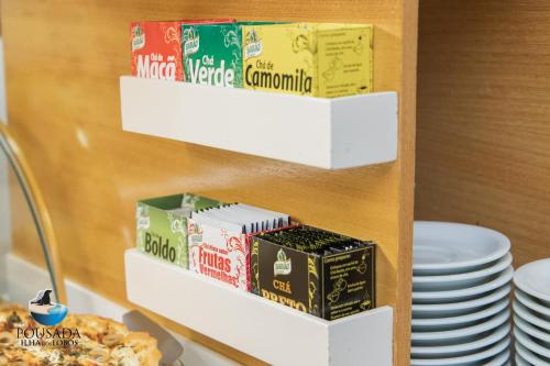 a shelf of food and plates on a counter at Pousada Ilha dos Lobos in Torres