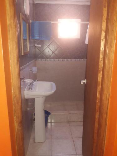 a small bathroom with a sink and a toilet at Las Hermanas in Las Grutas