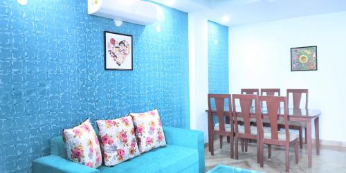 a blue living room with a couch and a table at 2BHK Short Stay Apartment walking Max Saket ( LIFT +Kitchen+Parking+3 nights min stay) in New Delhi