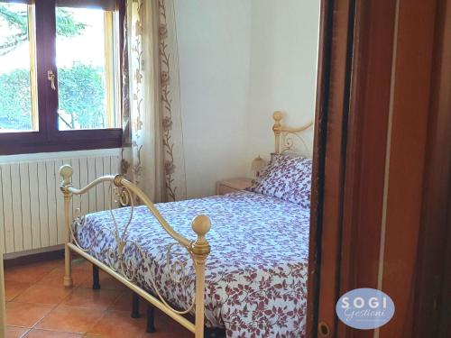 a bedroom with a bed with a blue and white comforter at Casa Sbrindoli in Lido di Jesolo