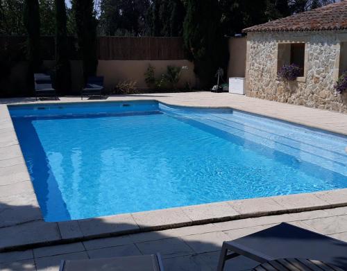 a swimming pool in a yard with a stone house at Le Mas des Vergers in Salon-de-Provence
