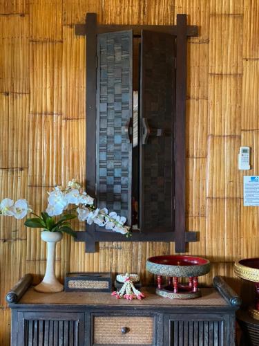 a table with a vase with flowers on it at Viking Nature Resort in Phi Phi Islands
