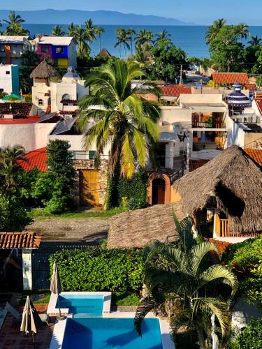 a view of a city with houses and a palm tree at Aventura Pacifico Boutique Suites & Villas in Bucerías