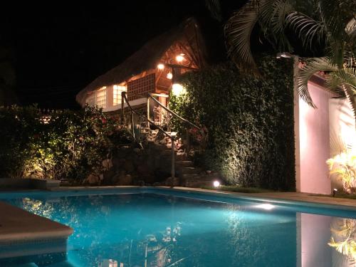 a swimming pool in front of a house at night at Aventura Pacifico Boutique Suites & Villas in Bucerías