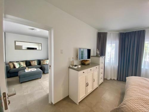 a bedroom with a bed and a living room at Palms & Pools apartment at Curacao Ocean Resort in Willemstad