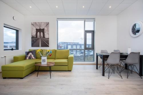 uma sala de estar com um sofá amarelo e uma mesa em Blue Mountain Apartments by Heimaleiga em Reykjavík