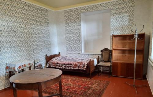 1 dormitorio con 1 cama, 1 mesa y 1 silla en The Lichk Lodge en Lichkʼ