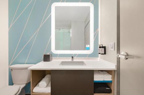 a bathroom with a sink and a mirror at avid hotels - Columbus Northwest - Hilliard, an IHG Hotel in Hilliard