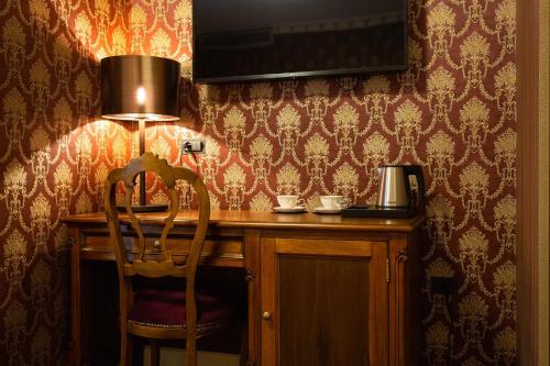 a desk with a chair and a lamp in a room at Envy Hotel in Durrës