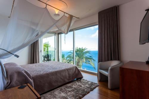 Un dormitorio con una cama y una ventana grande. en Casa Martinhos by LovelyStay, en Caniço