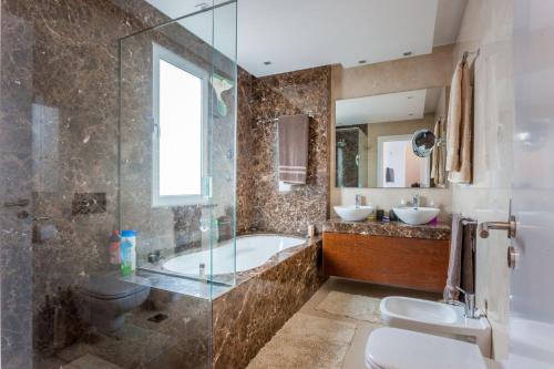 Un baño con bañera, inodoro y lavabo. en Casa Martinhos by LovelyStay, en Caniço