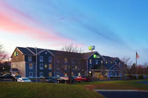 a large blue building with cars parked in a parking lot at Holiday Inn Express Grand Rapids Southwest by IHG in Grandville