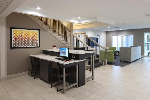 an office with a staircase and a desk with a computer at Holiday Inn Express Grand Rapids Southwest by IHG in Grandville