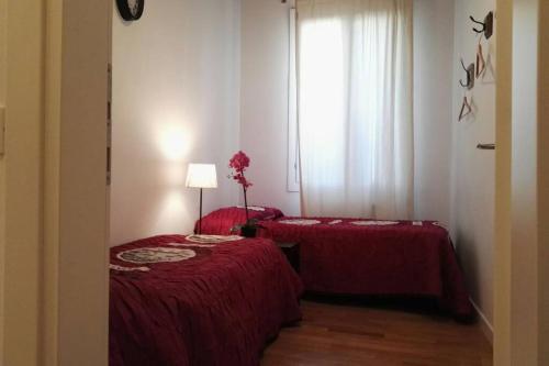 two red beds in a room with a window at CA MARIA IN ST MARK AREA in Venice