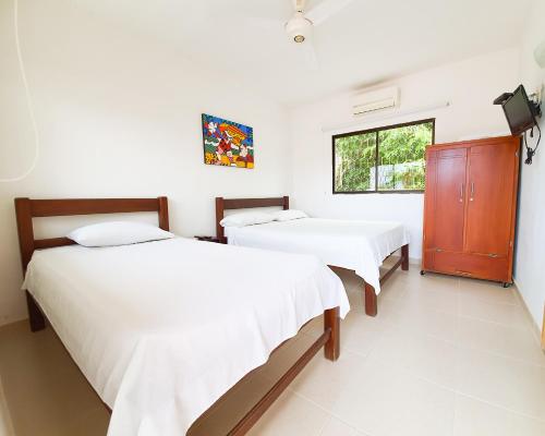 a bedroom with two beds and a window at Hotel Ocean Taganga Internacional in Taganga