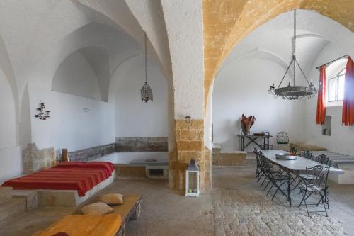 een slaapkamer met een bed en een tafel in een kamer bij Masseria Tornesella Don Giuliano in Parabita