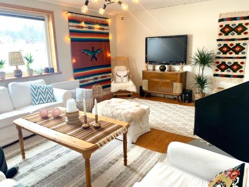 un soggiorno con mobili bianchi e TV a schermo piatto di Mysigt rum med privatbadrum a Västra Fors