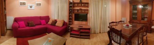 a living room with a purple couch and a table at El Pasaje in Arévalo