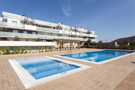 a large swimming pool in front of a building at Tejita beach , The beach dream flats in Granadilla de Abona