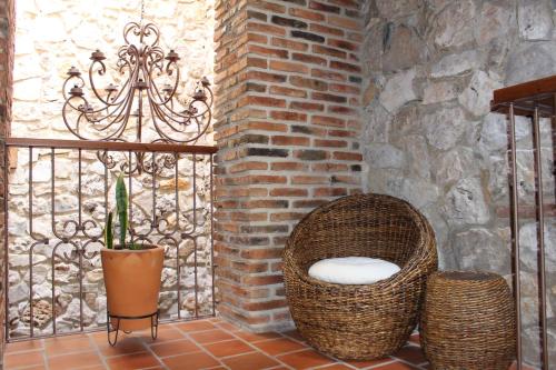 a balcony with a wicker chair and a brick wall at La Estancia in San Cristóbal de Las Casas
