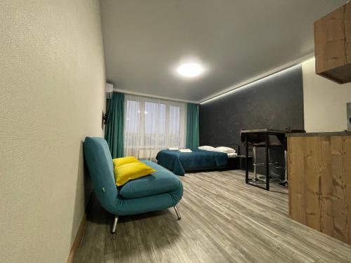 a room with two beds and a chair and a piano at Solo Apartment Kamenskaya in Kyiv