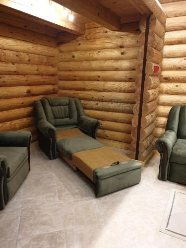 a living room with two chairs and a couch at Pušų Šlamesy in Vilnius