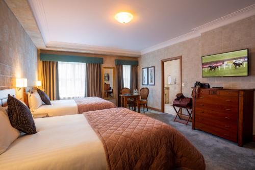 a hotel room with two beds and a dresser at Lawlors Hotel in Naas