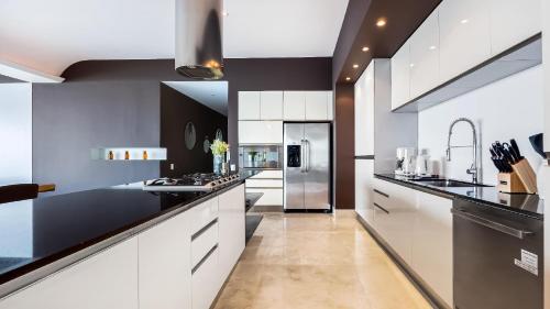a kitchen with white cabinets and black counter tops at Avalon - 401 Luxury & Breathtaking Sunset Views in Puerto Vallarta