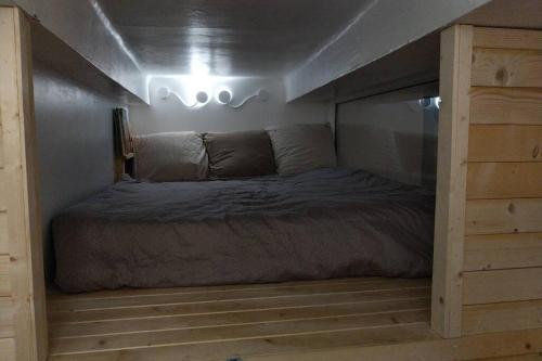 un lit dans une petite pièce avec dans l'établissement Chaleureux petit appartement de 4 couchages, à Saint-Étienne-de-Tinée