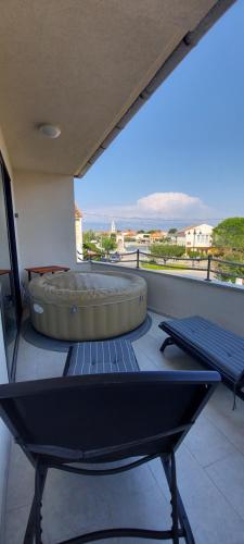 a large tub sitting on top of a balcony at Holiday home Velebit in Nin