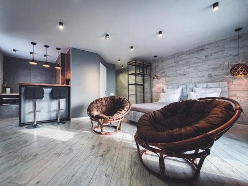 ein Hotelzimmer mit 2 Stühlen und einem Bett in der Unterkunft Ayezova 7, LOFT apartment in Öskemen