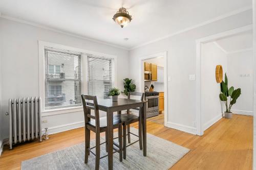 a dining room with a table and a kitchen at Vibrant 1BR Apartment in Roscoe Village - Marshfield N3 in Chicago