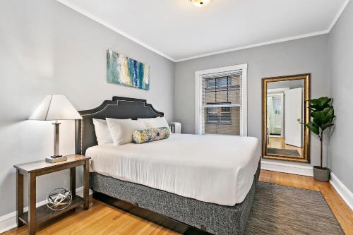 ein Schlafzimmer mit einem großen Bett und einem Spiegel in der Unterkunft 1-bedroom Cozy & Modish Apt - Marshfield W2 rep in Chicago