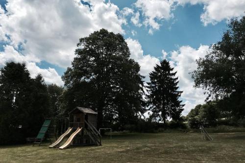 a playground with a slide and a play structure at Chalet N°5 in Treignes