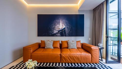 een bruine bank in een woonkamer met een foto van een boot bij PIER 57 - 610 2 BR & Best Sunset Rooftop in PV in Puerto Vallarta