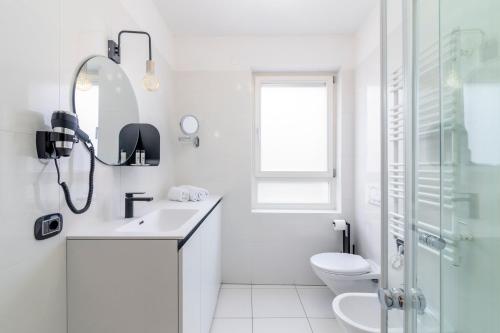 a white bathroom with a sink and a toilet at Stay COOPER l Cà de Bezzi in Bolzano