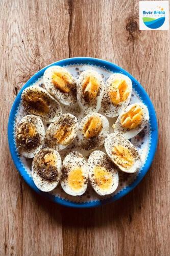 a blue plate with eggs on a wooden table at River Arena Holidays in Vagamon