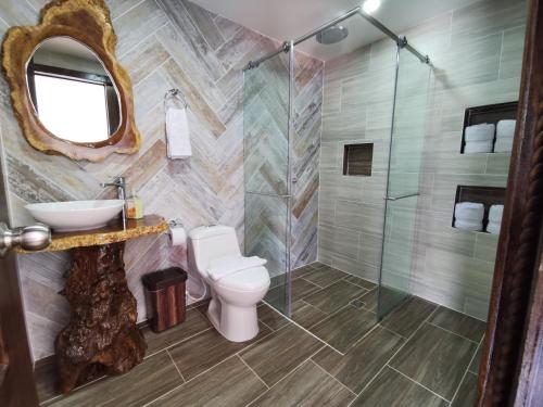 a bathroom with a toilet and a glass shower at Hospedaje Vista Hermosa Salento in Salento