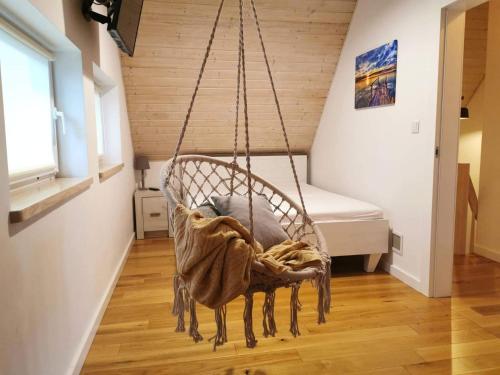 un fauteuil suspendu dans une chambre avec un lit dans l'établissement Relax Houses - Domy Mazur, à Małkinie